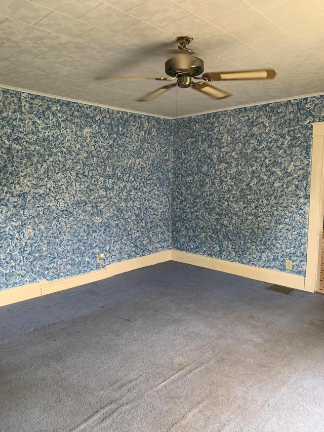 empty room featuring ceiling fan, carpet floors, and wallpapered walls