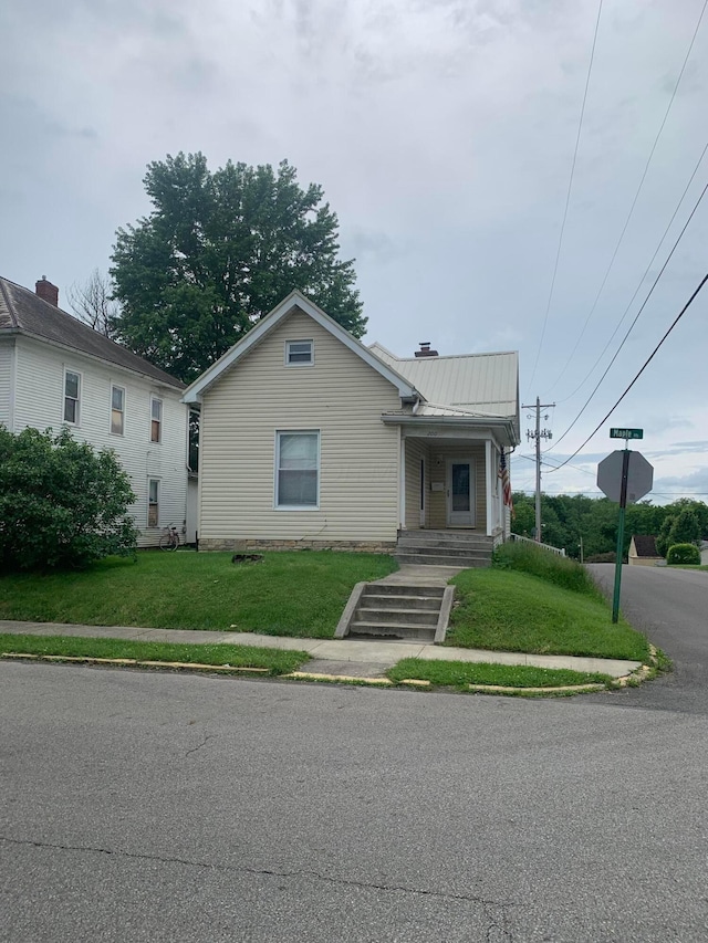 bungalow-style house with metal roof and a front lawn