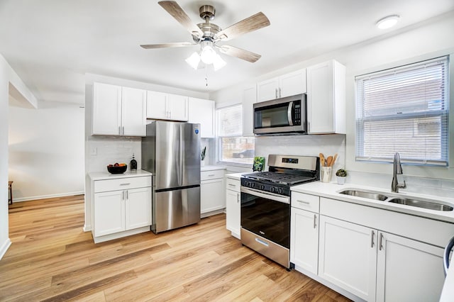 kitchen with light countertops, light wood-style floors, appliances with stainless steel finishes, and a sink