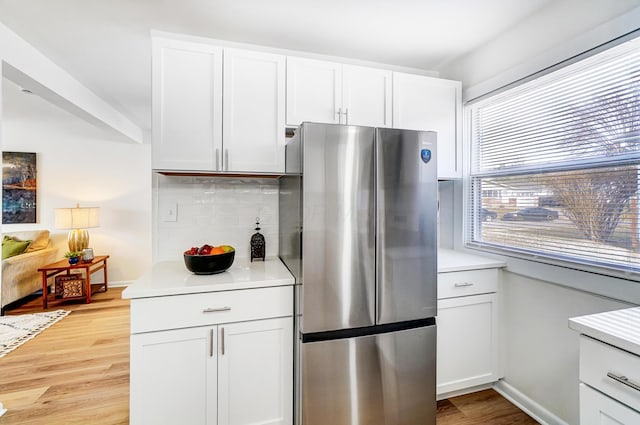 kitchen featuring white cabinetry, light countertops, light wood-type flooring, and freestanding refrigerator