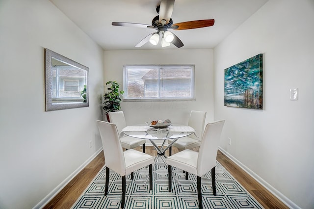 dining room with ceiling fan, baseboards, and wood finished floors