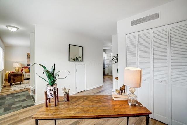 office area featuring light wood-style flooring, baseboards, and visible vents