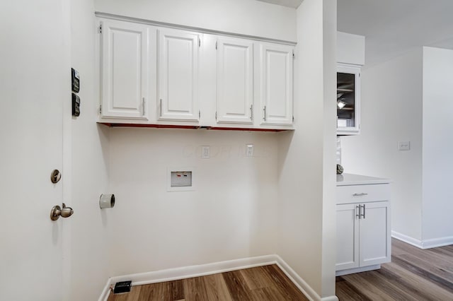 washroom with cabinet space, wood finished floors, baseboards, and washer hookup