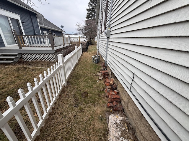 view of property exterior with fence and a wooden deck