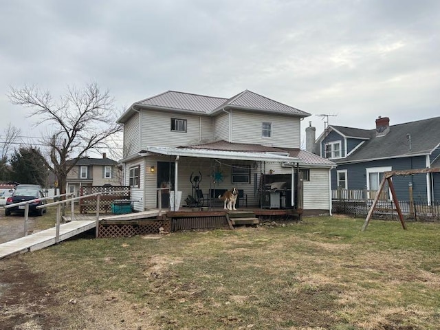 back of property featuring a deck, metal roof, and a yard