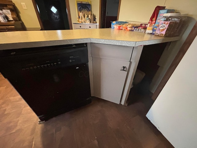 room details with black dishwasher, light countertops, and dark wood-style floors