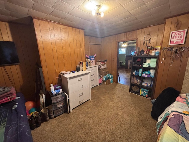 bedroom featuring carpet floors and wooden walls