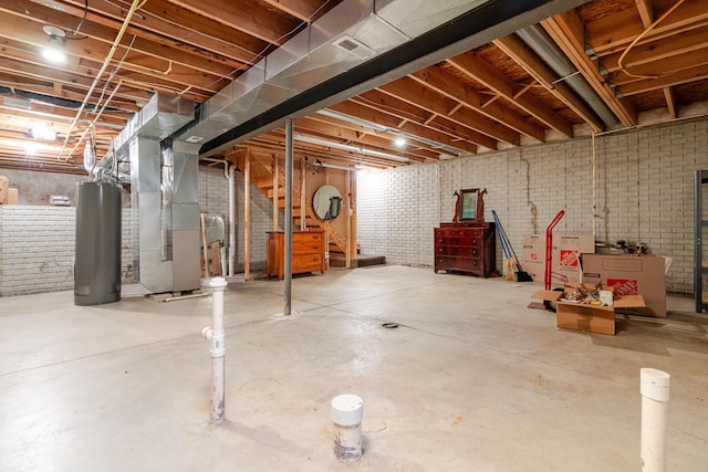 unfinished below grade area featuring heating unit, water heater, and brick wall