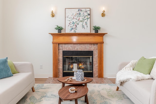 living area featuring a fireplace, wood finished floors, and baseboards