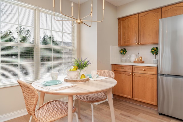 dining space with light wood-type flooring and baseboards