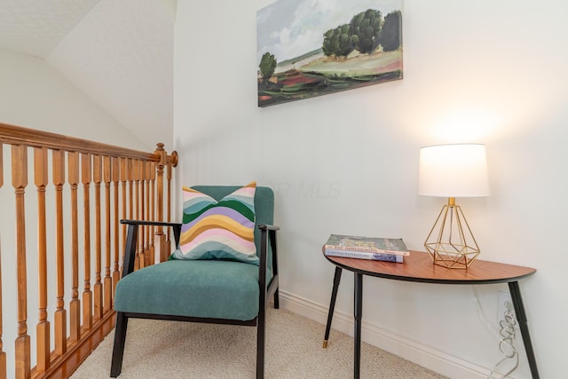 living area with vaulted ceiling, carpet, and baseboards