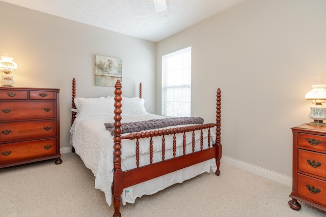 bedroom with light carpet, ceiling fan, a textured ceiling, and baseboards