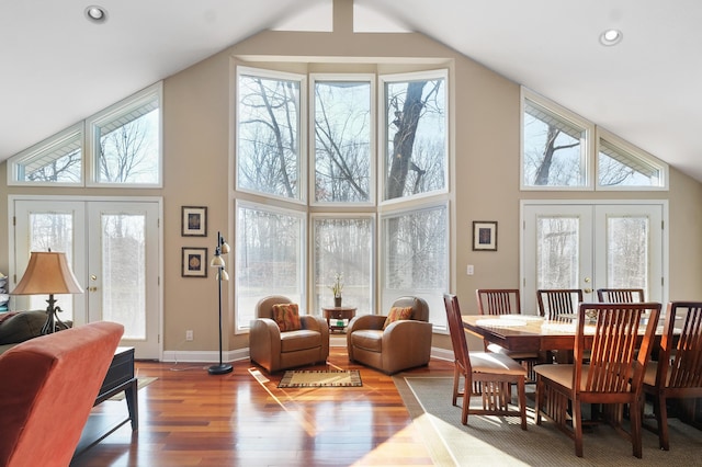 dining space featuring high vaulted ceiling, wood finished floors, recessed lighting, french doors, and baseboards