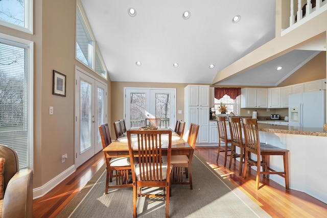 dining area with baseboards, recessed lighting, french doors, wood finished floors, and high vaulted ceiling