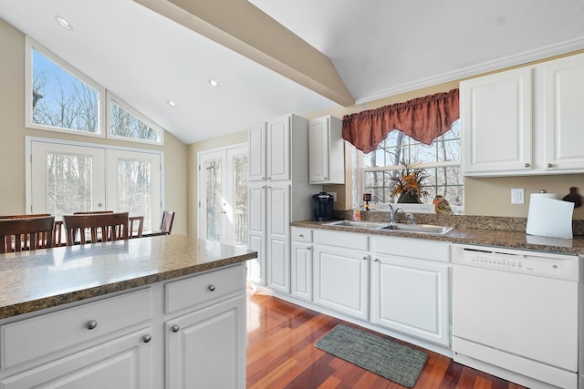 kitchen featuring vaulted ceiling, dark wood-style flooring, french doors, white dishwasher, and a sink