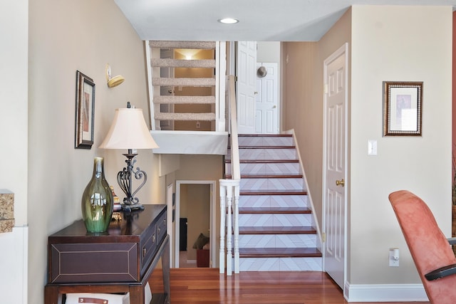 stairway with recessed lighting and wood finished floors