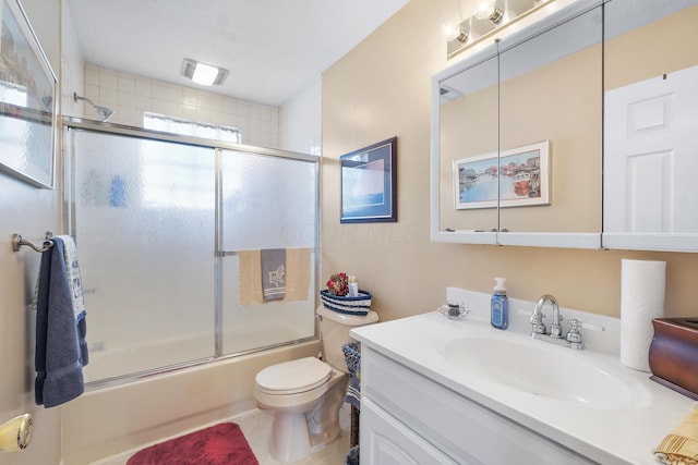 bathroom featuring combined bath / shower with glass door, toilet, vanity, and tile patterned floors