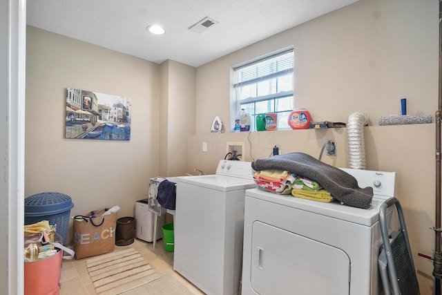 washroom with laundry area, light tile patterned floors, separate washer and dryer, and visible vents