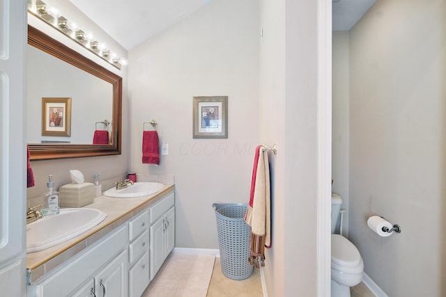 full bathroom featuring double vanity, toilet, baseboards, and a sink