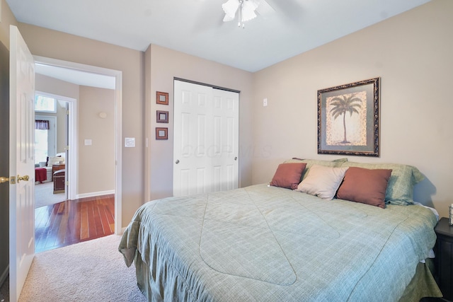 bedroom featuring a closet, a ceiling fan, baseboards, and wood finished floors