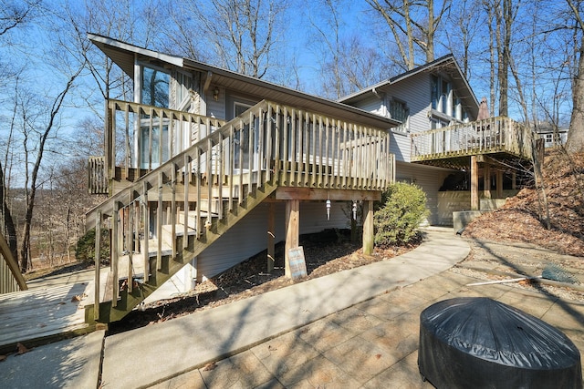 rear view of property with stairway and a deck