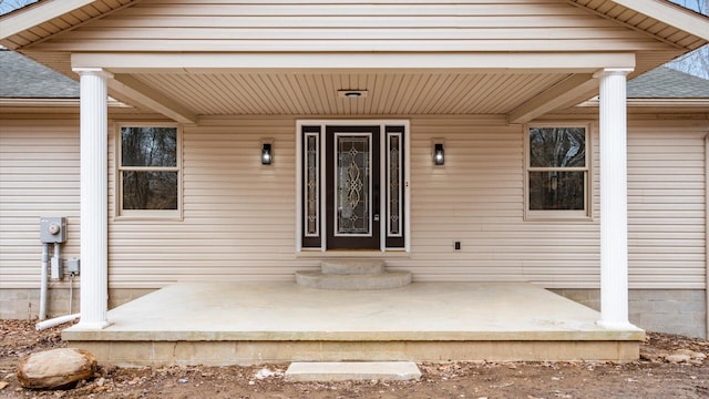 entrance to property featuring roof with shingles