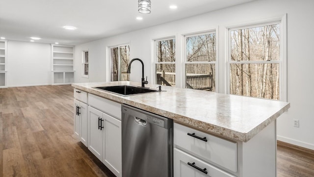 kitchen with built in features, wood finished floors, stainless steel dishwasher, a sink, and recessed lighting