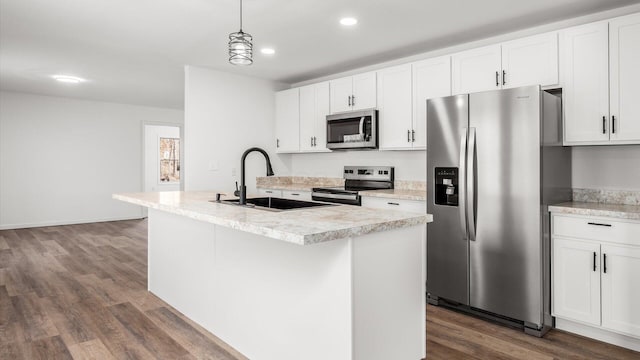 kitchen featuring appliances with stainless steel finishes, dark wood-type flooring, white cabinets, a kitchen island with sink, and a sink