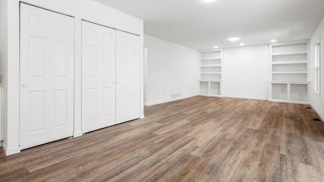 interior space with baseboards, visible vents, wood finished floors, and recessed lighting