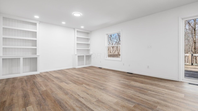 unfurnished room featuring recessed lighting, wood finished floors, visible vents, built in features, and baseboards