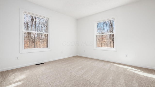 carpeted spare room with baseboards and visible vents