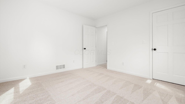 unfurnished bedroom with carpet flooring, visible vents, and baseboards