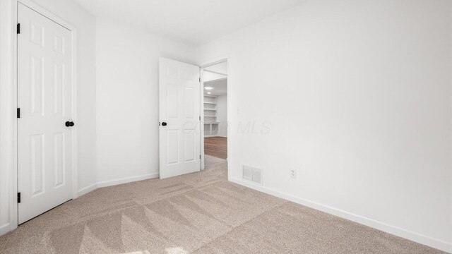 unfurnished bedroom with baseboards, visible vents, and carpet flooring