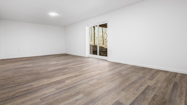 spare room with wood finished floors and baseboards