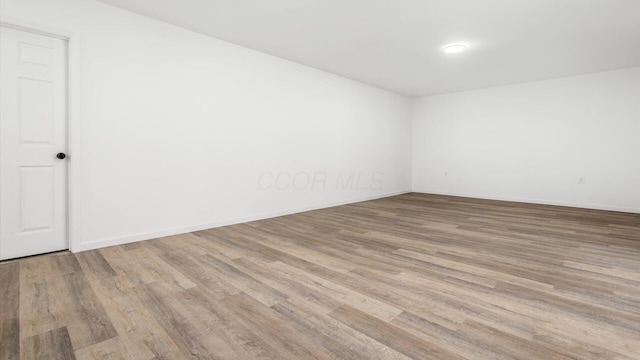 unfurnished room featuring wood finished floors and baseboards