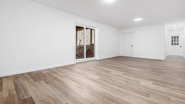 empty room featuring light wood-style flooring, baseboards, and recessed lighting