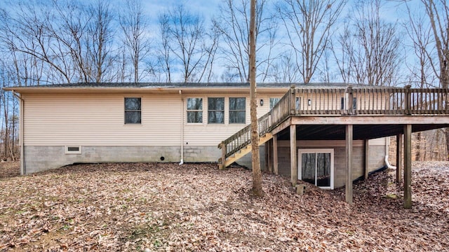 back of property featuring stairway and a deck