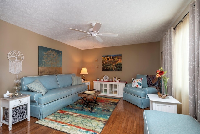 living area featuring a textured ceiling, wood finished floors, and ceiling fan