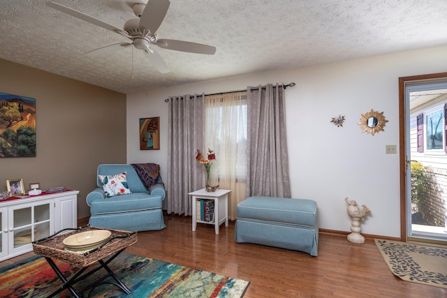 sitting room with a textured ceiling, ceiling fan, and wood finished floors