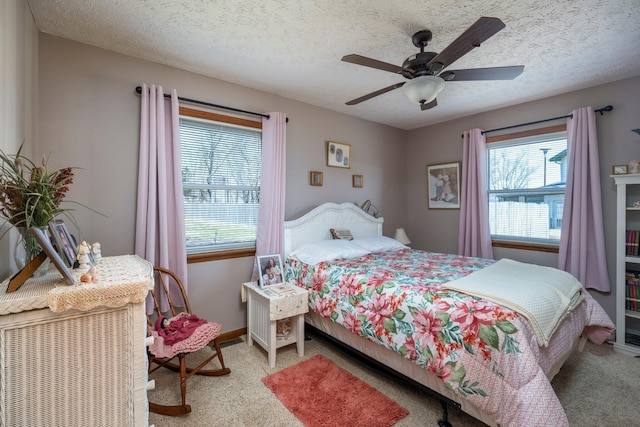 bedroom with baseboards, a textured ceiling, a ceiling fan, and carpet