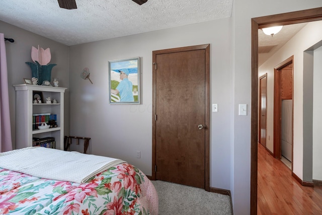 bedroom with ceiling fan, baseboards, and a textured ceiling