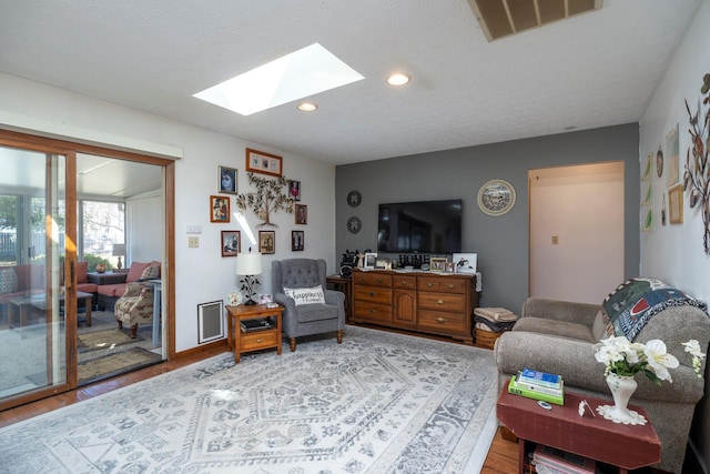 living room featuring visible vents, recessed lighting, a skylight, and light wood-type flooring