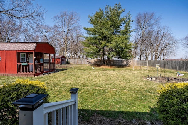 view of yard with a deck, an outbuilding, and a fenced backyard