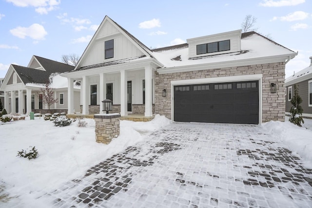 view of front of home featuring a garage, a porch, board and batten siding, and decorative driveway