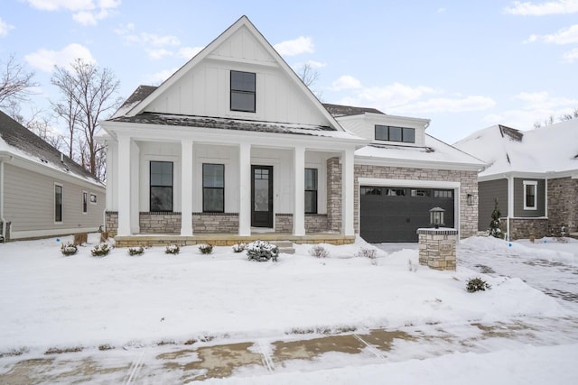 modern inspired farmhouse featuring board and batten siding, covered porch, stone siding, and a garage