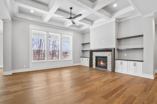 unfurnished living room featuring a fireplace, ceiling fan, coffered ceiling, beamed ceiling, and hardwood / wood-style floors