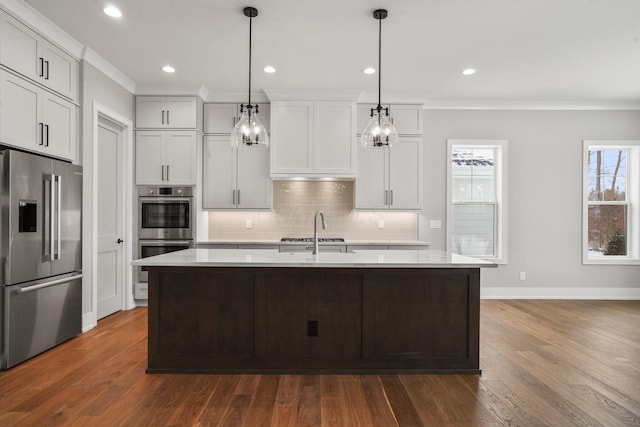 kitchen with backsplash, crown molding, stainless steel appliances, and light countertops