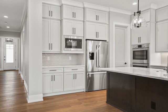 kitchen featuring appliances with stainless steel finishes, crown molding, and decorative backsplash