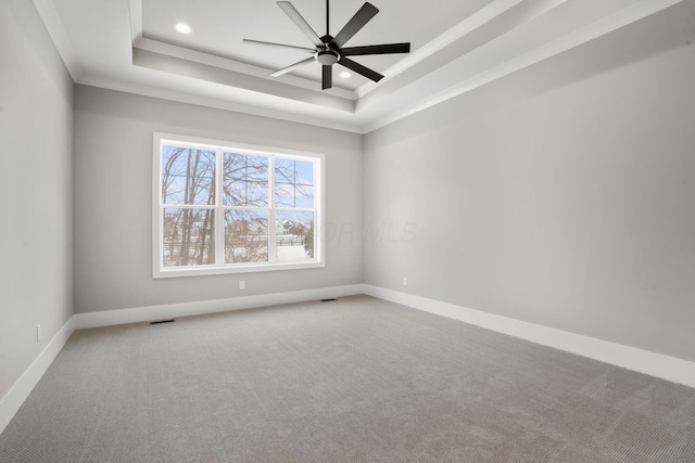 empty room with carpet floors, a tray ceiling, recessed lighting, ceiling fan, and baseboards