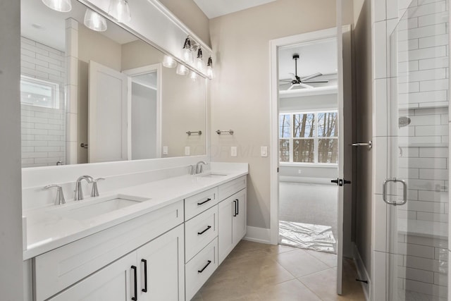 full bath with a tile shower, double vanity, a sink, and tile patterned floors